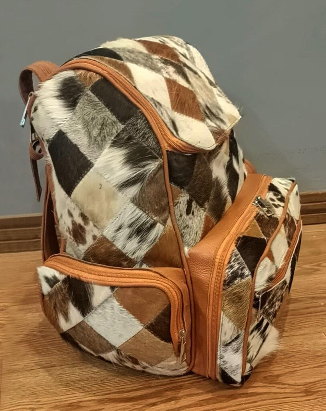 Brown and white cowhide backpack on display, cowhide side image